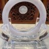 A clear glass sculpture with an open circle on top.