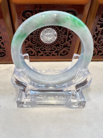 A green and white bangle sitting on top of a glass holder.