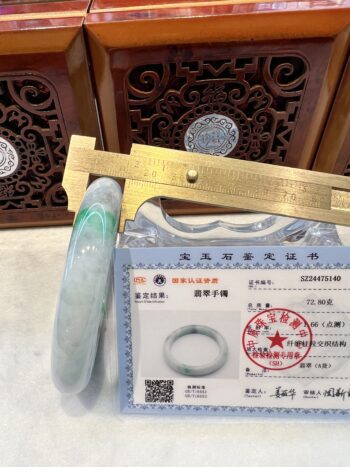 A gold ruler and some rings on top of a table.