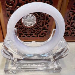 A white ring sitting on top of a clear glass object.