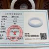 A white ring is sitting on top of a certificate.