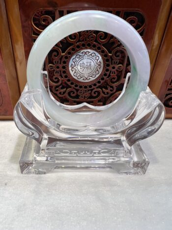 A clear glass sculpture with a circular design.