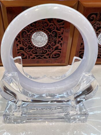 Clear glass ring on decorative wooden stand.