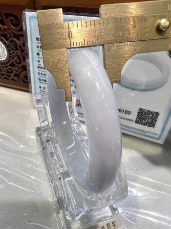 Caliper measuring a white jade bracelet.