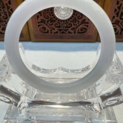 Smooth white jade cuff displayed on plinth