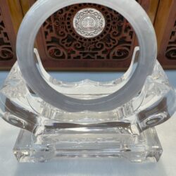Milky jade ring displayed on crystal stand