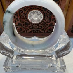 White and green jade bangle displayed upright