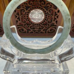 Translucent pale green jade bangle displayed
