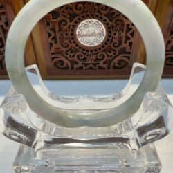 Green veined jade bangle framed by ornate carving