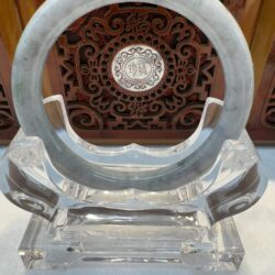 Circular jade bangle centered over ornate carving
