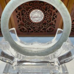 Light green jade circle with carved wood backdrop