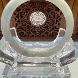 Jade ring on a decorative wooden stand.
