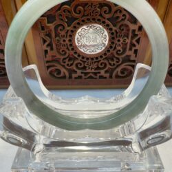 Green jade bangle on ornate stand display.