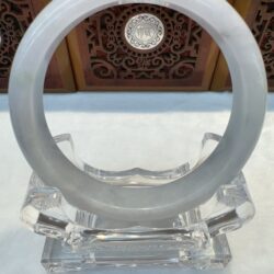 White circular sculpture on a clear stand.