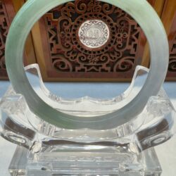 Green jade ring on ornate display stand.