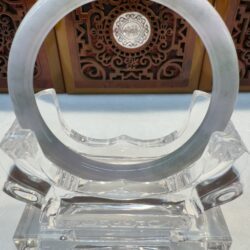 Transparent circular object on a clear stand.