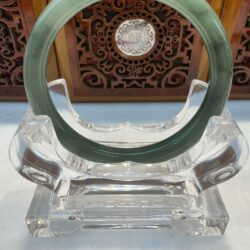 Veined green jade bangle with wooden backdrop