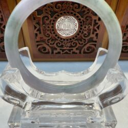 Clear circular sculpture with decorative background panel.