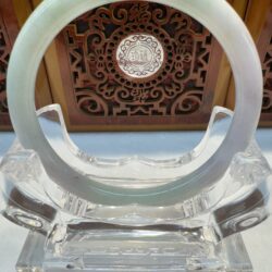 Translucent green jade circle on acrylic base