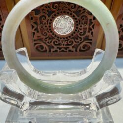 Translucent jade bangle displayed on acrylic stand