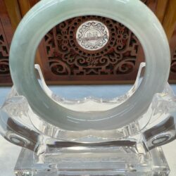 Jade ring on an ornate wooden stand.