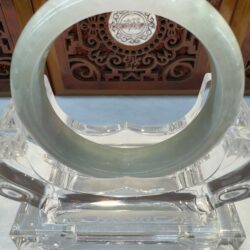Translucent light green jade bangle on stand
