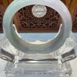 Round jade bracelet displayed on lucite holder