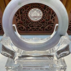 Translucent jade circle displayed with carved panel
