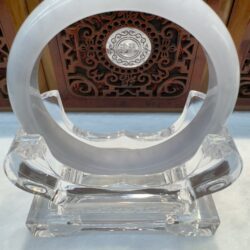 Crystal sculpture with circular design and engravings.