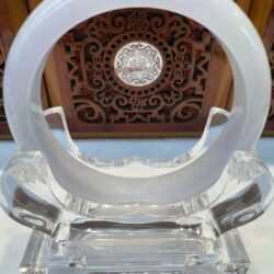 Circular sculpture with intricate wooden background.