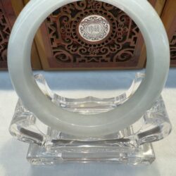 Circular jade bangle over decorative medallion backdrop