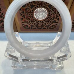 White bangle on clear display stand.