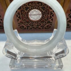 Light green jade hoop on clear pedestal