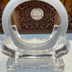 Circular crystal sculpture with intricate background design.