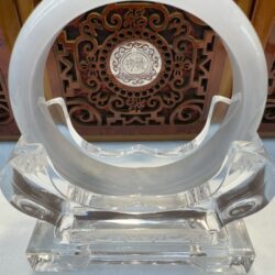 Crystal ring with intricate wooden background.