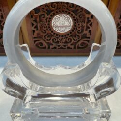 Translucent jade bi on crystal stand