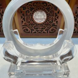 Circular milky jade hoop displayed on lucite