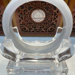 Crystal sculpture with intricate wooden background.