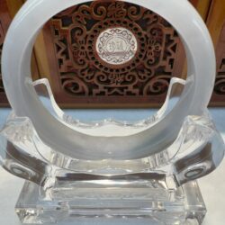 Ornate circular crystal sculpture on display stand.