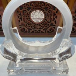 Smooth pale bangle resting in crystal holder