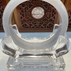 Transparent glass sculpture with circular design.