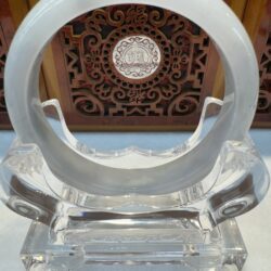 Crystal ring display with ornate wooden background.