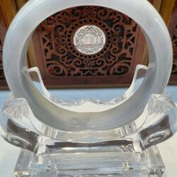 Glossy circular jade bangle with carved backdrop