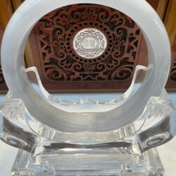 Crystal ring on ornate wooden stand.