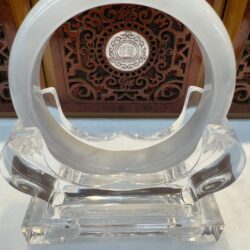 Circular sculpture with intricate wooden background design.