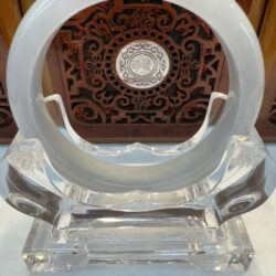 Clear circular stand with ornate red background.