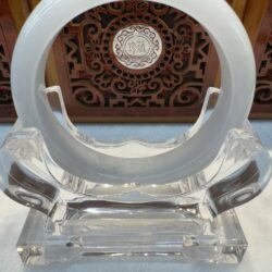 Translucent round jade displayed on acrylic base