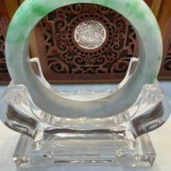 Green jade circle on clear stand.