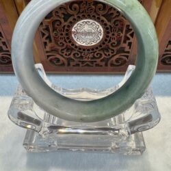 Pale green jade bangle on crystal stand