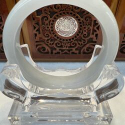 Translucent white jade bangle on crystal stand